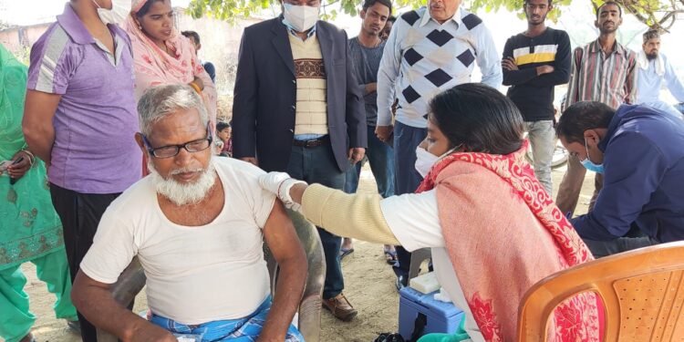 Vaccination in progress at Banjari village under the Chainpur police station in Palamu following the persuasion of the SDO sadar Rajesh kr Sah (in black coat)