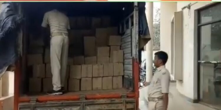 Seized liquor cartons being uploaded by cops from one of the trucks on the Parsudih thana premises